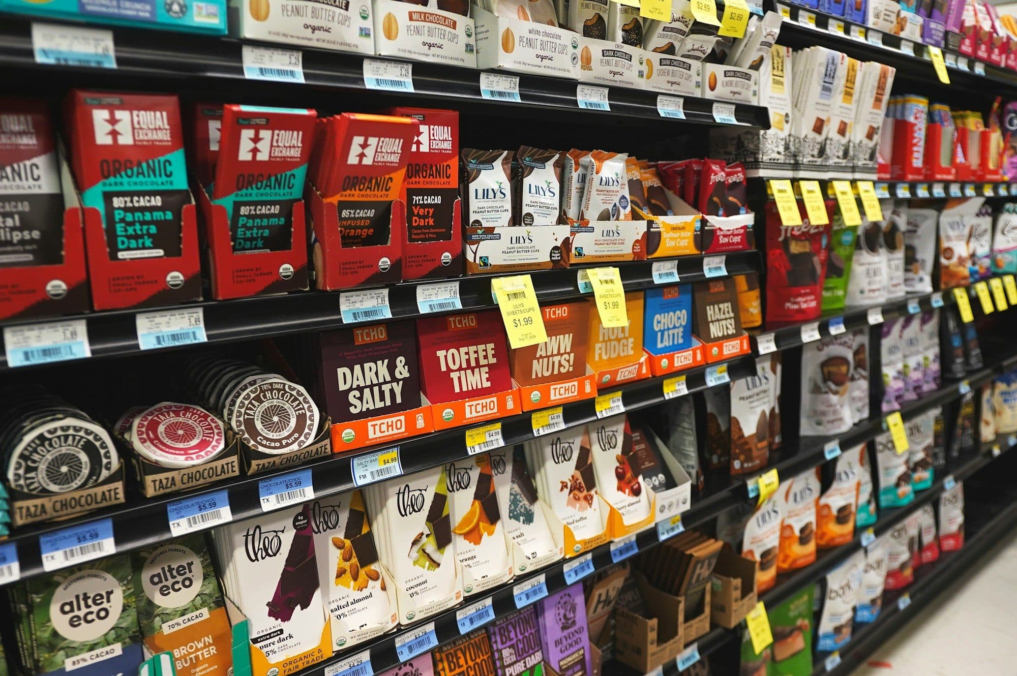A supermarket aisle stocked with packaged snacks and chocolate